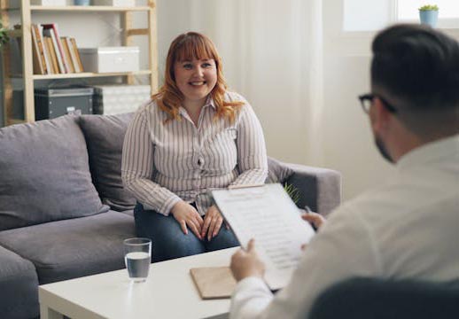 A woman smiles while taking to a mental health therapist