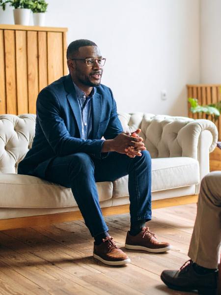 psychotherapy-session A man sitting on the edge of a couch and talking during a psychotherapy session