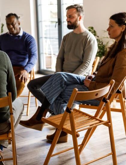 Members of a support group therapy session listen to an unseen group participant