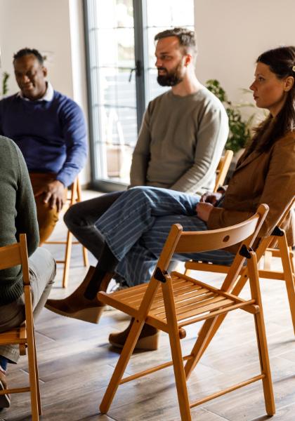Members of a support group therapy session listen to an unseen group participant