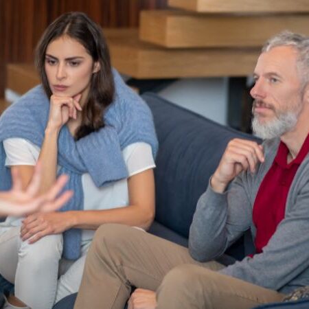 A couple sit an listen to someone not pictured during a family discussion and mental health intervention